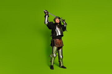 Portrait of a Young Male Knight in Steel Armor with a Sword on a Vibrant Green Background