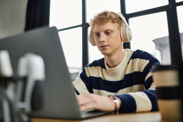 A focused young man with red hair collaborates professionally in a stylish office space.
