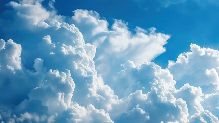 Naklejka premium Fluffy white clouds in a bright blue sky create a serene and peaceful atmosphere, ideal for nature and outdoor themes