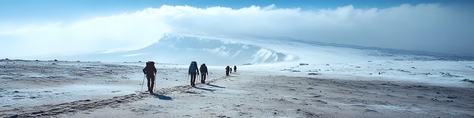 Wide shot of climbers crossing the alpine desert zone on the way to the summit, with Kilimanjaros glaciers shimmering in the distance, in 4K resolution