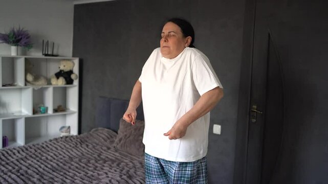     senior woman performs somatic exercises, yoga at home