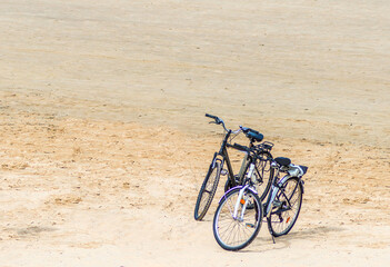 Fototapeta premium Couple of bicycles at sandy beach of the Baltic Sea in Jurmala - famous tourist resort in Latvia at summer season. Healthy and sport life style concept. No AI tools were used