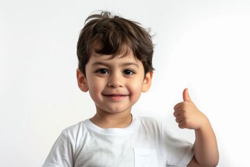 Young child giving a thumbs up against a plain background during a cheerful moment of affirmation and happiness