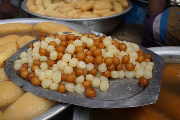 Popular Bangladeshi dessert Gulab Jamun with sugar syrup, Traditional Bangladeshi sweet called rasgulla or rasgoola is being sold at a market, Gulab jamun and rasgulla are displayed together