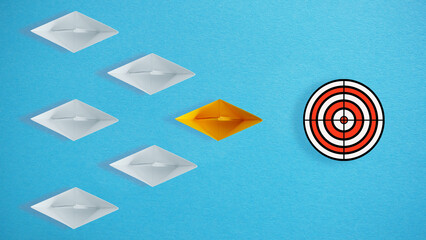 Leadership and achieving goals concept. Yellow paper ship is leading a group of white paper ships...