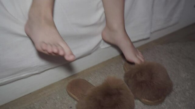 child getting out of bed at night and putting on slippers, at night a little girl got out of bed and put on slippers and went to another room