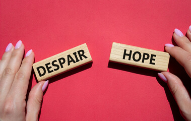 Despair or Hope symbol. Concept word Despair or Hope on wooden blocks. Businessman hand. Beautiful red background. Business and Despair or Hope concept. Copy space