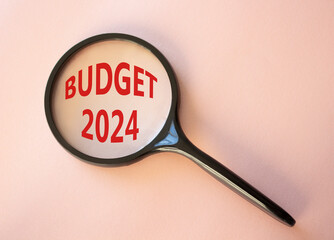 Budget 2024 symbol. Magnifying Glass with words Budget 2024. Beautiful pink background. Business and Budget 2024 concept. Copy space.