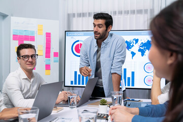 Analyst team utilizing BI Fintech to analyze financial data at table in meeting room. Businesspeople analyzing BI dashboard power for business insight and strategic marketing planning. Prudent