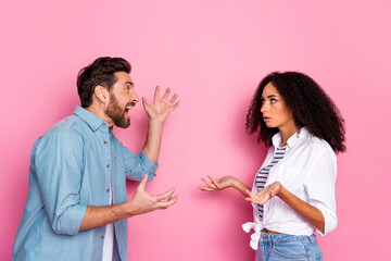 Young couple arguing against pink background, expressing disagreement
