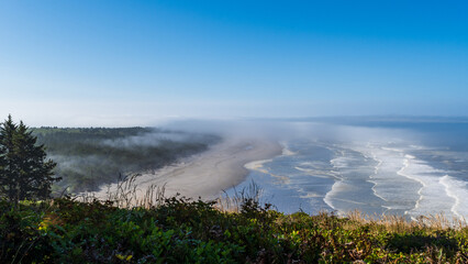 Waves roll ashore near Cape Disappointment State Park on a cloudy morning, Washington, USA.