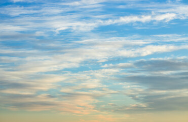 A beautiful sky tinted by the sun leaving vibrant shades of gold, pink, blue and multicolored. Clouds in the twilight evening and morning sky. Cloudy sky background in the evening, and during the day.
