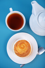 Croissant roll with mango in a plate on a blue background