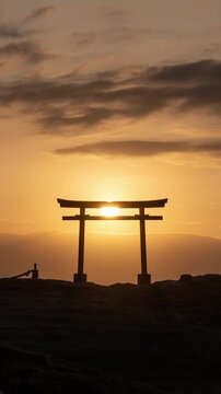 海辺の鳥居越しに昇る朝日のタイムラプス映像（コンセプト：初日の出・新年）（縦・フィックス）