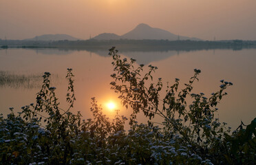 sun sets over Muradi hill in Baranti (or Barhanti) village, Purulia district. Reflection of the hill in calm waters of Baranti lake created a picturesque nature canvas in dawn.