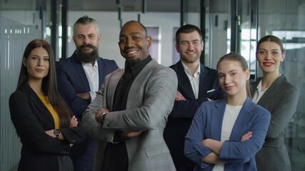 Confident and diverse group of business professionals standing together in a modern office environment, smiling and displaying unity. Concept of teamwork, leadership, and collaboration