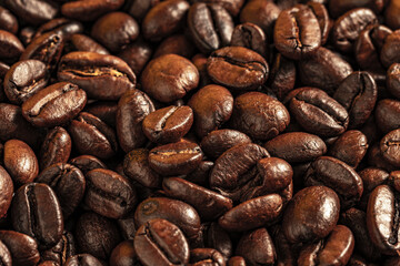 Aromatic Roasted Coffee Beans Textured Background. Close-up of roasted coffee beans forming a textured background. Perfect for concepts related to coffee production, brewing, café culture