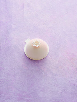 Delicious Modern Dessert Delicately Crafted With Floral Decoration on a Pastel Purple Surface
