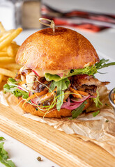 Vegetarian fresh burger with mushrooms and vegetables, served with french fries on wooden board