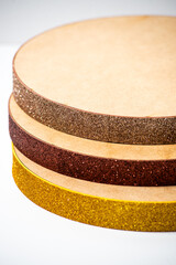 Round cake boards in various colors stacked on a white background