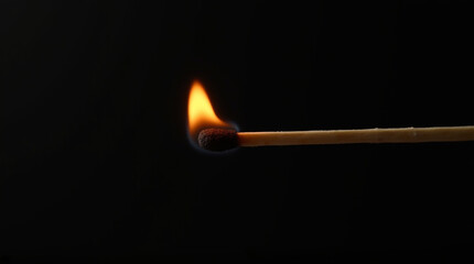 Burning match on black background