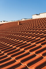 close-up of a roof built with orange-colored ceramic tiles