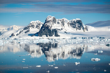 Stunning snowy mountain landscape reflecting in the water, Hanusse Bay, Antarctica