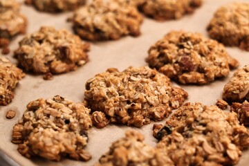 The process of preparing homemade oatmeal cookies - baked cookies placed on a baking tray lined with baking paper