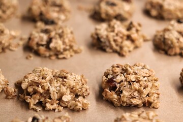 The process of preparing homemade oatmeal cookies - raw, formed cookies placed on a baking tray lined with baking paper
