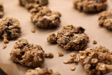 The process of preparing homemade oatmeal cookies - raw, formed cookies placed on a baking tray lined with baking paper