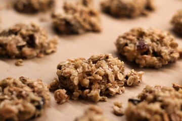 The process of preparing homemade oatmeal cookies - raw, formed cookies placed on a baking tray lined with baking paper