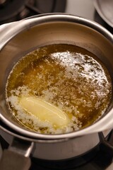 The process of preparing homemade oatmeal cookies - butter and honey melted in a metal bowl