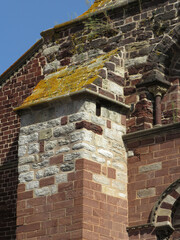 Romanesque Basilica of Saint Julian of Briuode. France.
Detail of buttress with ashlars in colorful stones. 