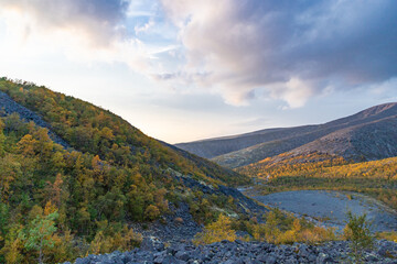 View to Mannepakhp river valley at Khibiny mountains. Stones and small trees. Early autumn in arctic tundra region. Kola peninsula, Murmansk region, Russia.