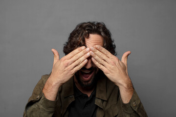 smiling and feeling happy, covering eyes with both hands and waiting for unbelievable surprise