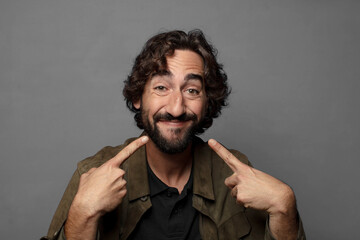 smiling confidently pointing to own broad smile, positive, relaxed, satisfied attitude