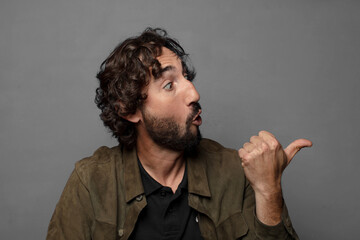 looking astonished in disbelief, pointing at object on the side and saying wow, unbelievable