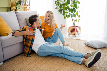 Full size photo of cute young couple sit floor chatting relax have fun cozy day light spring summer home interior living room