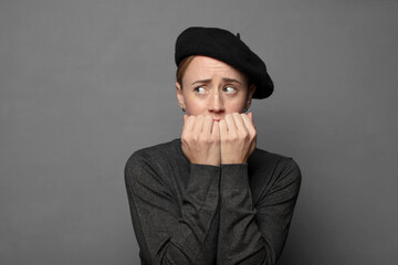 looking worried, anxious, stressed and afraid, biting fingernails and looking to lateral copy space