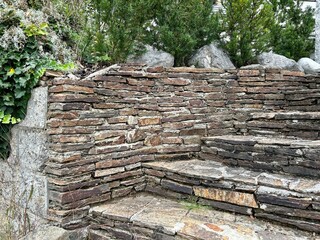 Vintage garden design and landscaping: Outdoor stairway and wall at a hillside plot with pavement made of old nature stone tiles with gaps permeable to air and water-  ecology concept, sustainability