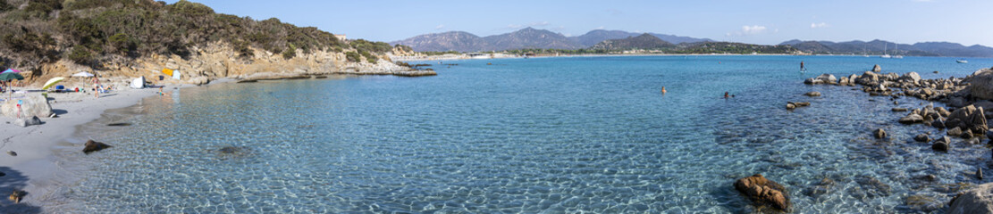 Fototapeta premium Extra wide view of The beautiful Cala Porto Giunco ​​with crystal clear, blue and turquoise water