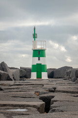 Green and white striped lighthouse on a causeway in the Algarve, Portugal