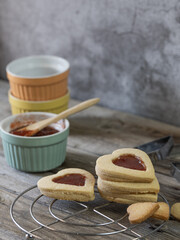 Heart shaped cookies decorated with strawberry jam along with kitchen utensils