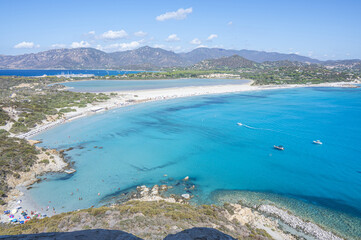 VIllasimius, Italy - 09-05-2024: Aerial view of the beautiful beach of Porto Giunco ​​in Villasimius with white sand and crystal clear water with the Notteri pond in the background