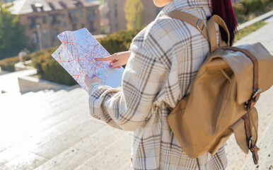 Tourist with map in hand orienting himself in the city