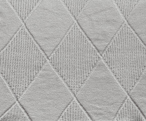 Grey wool knitted pattern with diamond shapes,  texture background