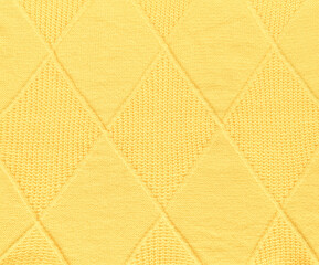 Yellow wool knitted pattern with diamond shapes,  texture background