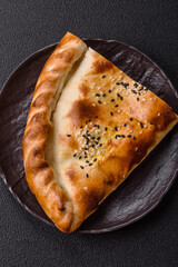 Cheburek meat pastry pie with herbs on the concrete background