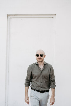 Mann, 40, mit Glatze und Sonnenbrille