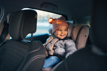 Happy and Adorable Toddler Sitting in a Car Seat on a Winter Day